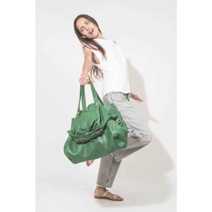 Sac forme cabas en cuir vert gazon Billy M Jérôme Dreyfuss. Porté main avec un tee-shirt sans manches blanc Nayda Marant Etoile et un jean large gris Betty Haikure. Sandales plates en cuir argent Caravelle K.Jacques St-Tropez. Bagues Harpo en argent et tu