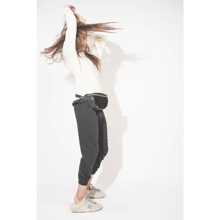 Sac banane en cuir chèvre grainé noir Lino Jérôme Dreyfuss. Porté de profil avec un sweat-shirt écru Shrunken The Great et un pantalon de jogging court noir The Great. Sneakers Super Star sabot en Shearling écru Golden Goose.