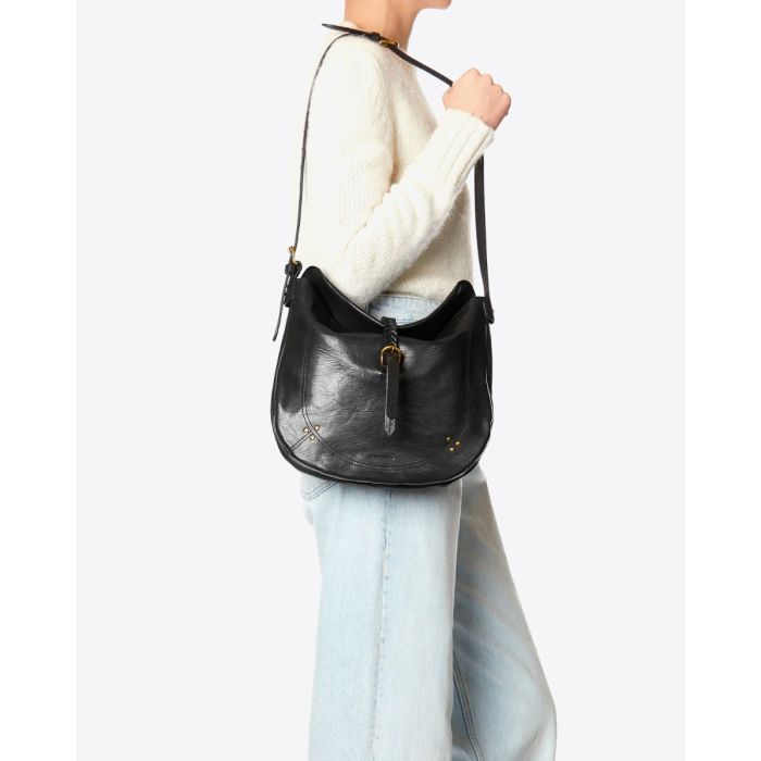 Sac besace Luis Jérôme Dreyfuss en cuir de chèvre noir grainé porté à l'épaule.
