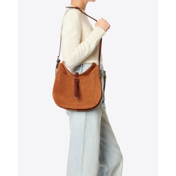 Sac besace Luis Jérôme Dreyfuss en cuir suédé caramel porté à l'épaule.