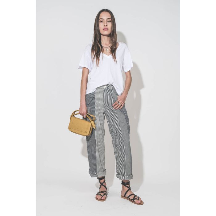 Sandales plates en cuir noir Zenobie K.Jacques Saint-Tropez. Portées avec un tee-shirt col V blanc The Great, un pantalon Cargo à rayures R13 denim et un sac en cuir jaune Mimosa Pepito S Jérôme Dreyfuss. Bague en argent Mikuta.