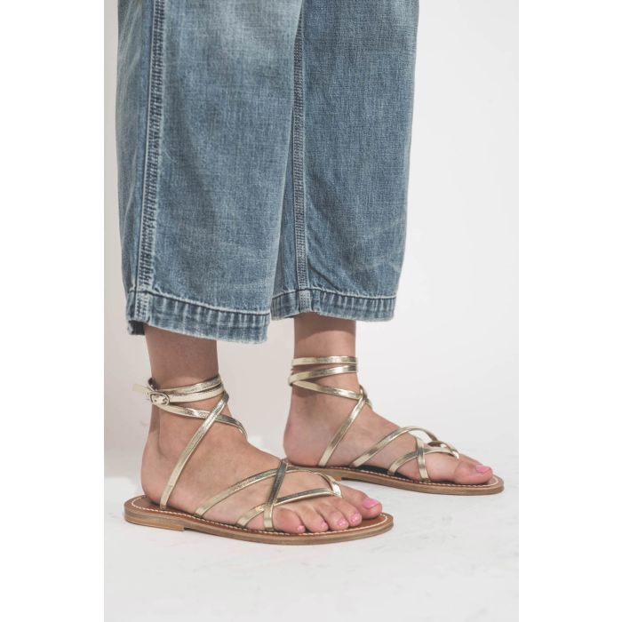 Sandales en cuir doré Metyl Champan Zenobie K.Jacques St-Tropez. Porté de profil avec une salopette en jean bleu ciel Denimist.
