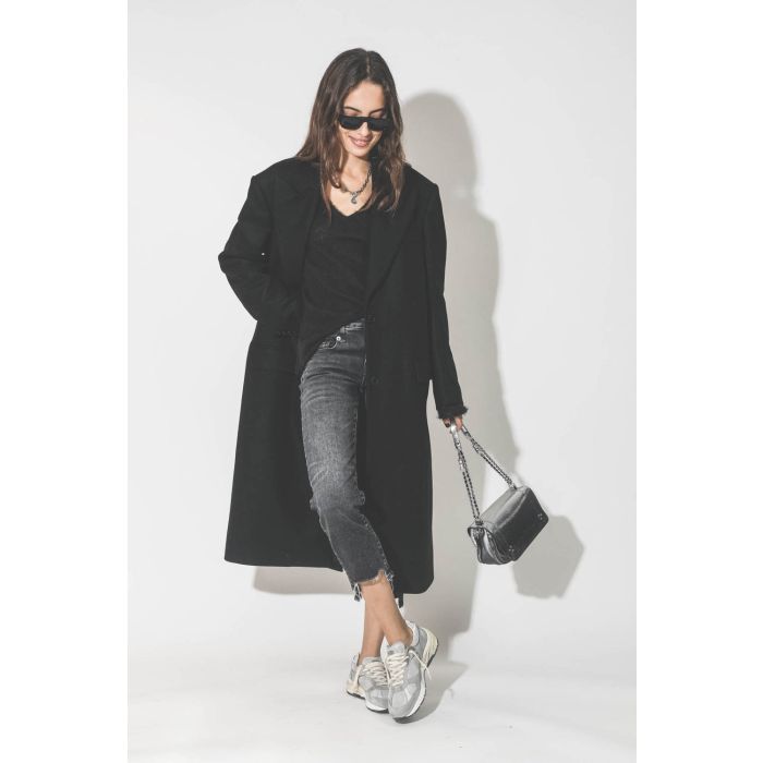 Manteau long en drap de laine noir Maison Flaneur. Porté avec un jeans court et des sneakers.