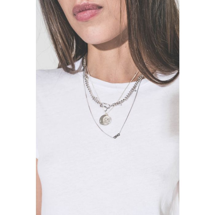 Collier long chaine avec lettre Dad en argent Maria Black. Porté en accumulation avec un collier chaine Berline en argent et un collier L'amour en argent Pascale Monvoisin. Tee-shirt blanc col rend The Great. 