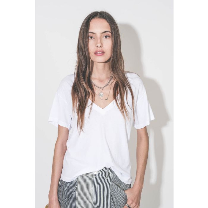 Collier long chaine avec lettre Dad en argent Maria Black. Porté en accumulation avec un collier chaine Berline en argent et un collier L'amour en argent Pascale Monvoisin. Tee-shirt blanc col V neck The Great.