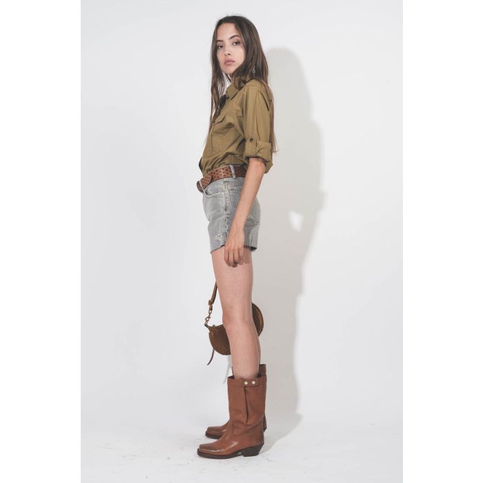 Short taille haute court en jean kaki Mikuta. Porté de profil.
