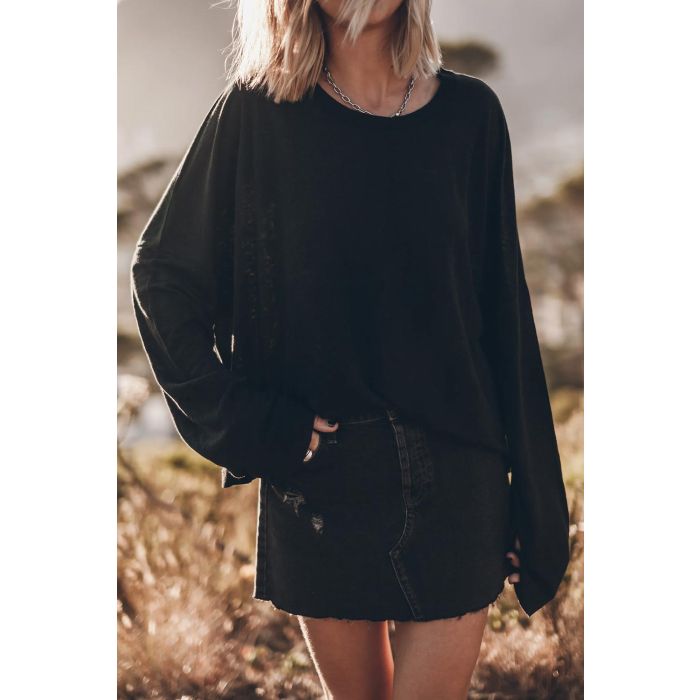 Tee-shirt Oversized Mikuta en lin noir. Vue face porté avec une jupe en denim noir. 