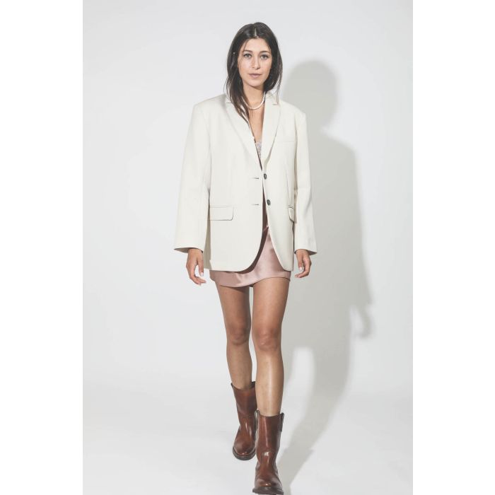 Robe fines bretelles courte en satin et dentelle rose Romina Anine Bing. Porté avec un blazer écru.