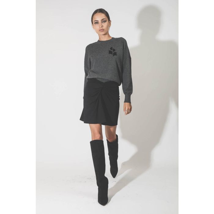 Mini-jupe en jersey noir drapé Natacha Marant Etoile. Porté avec des bottes en cuir suédé noir.