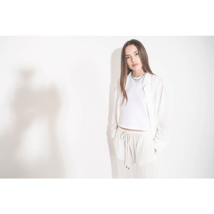 Collier ras du cou en turquoise et chaines en or jaune Taylor N°3 Pascale Monvoisin. Porté sur un tee-shirt blanc Peak Shoulder The Great et une chemise en voile de coton blanche Cove The Great et un pantalon sarouel Reef The Great.
