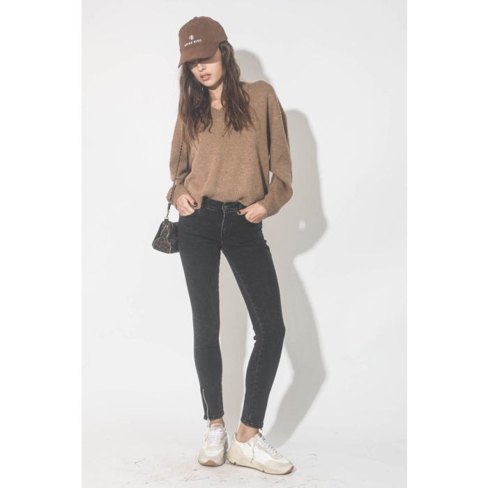Pull col V en cachemire camel Lee Anine Bing. Porté avec un jeans noir.