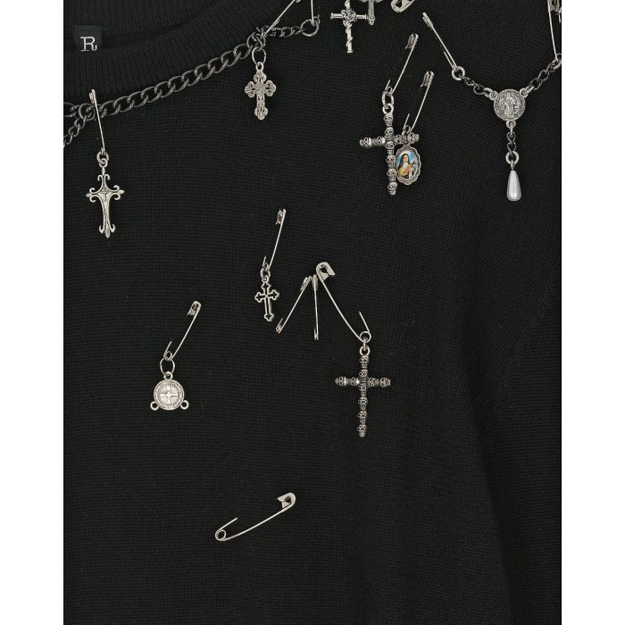 Pull Tight Waist Crewneck Sweater R13 en laine noire, orné de bijoux argentés. Détails des bijoux croix, épingles à nourrice, médailles.