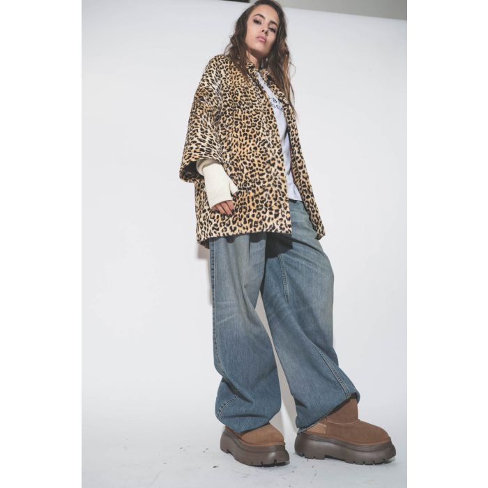 Boots courtes fourrées en peau de mouton retournées Chunky R13. Porté avec un jean bleu et un manteau léopard.