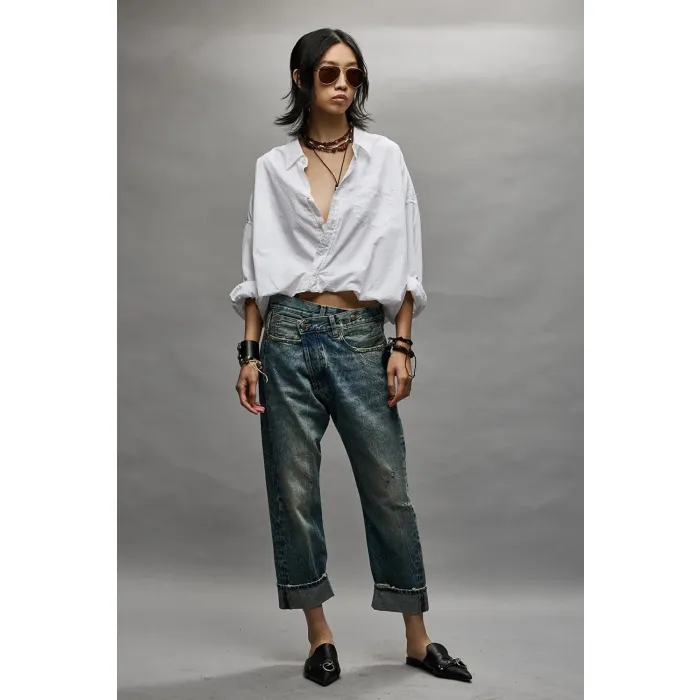 Jean Crossover bleu délavage Kelly R13 Denim. Porté avec une chemise blanche.