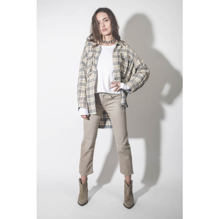 Jean skinny taille basse Boy Straight en jean beige Buff Stretch R13. Porté avec une chemise oversize à carreaux beige.