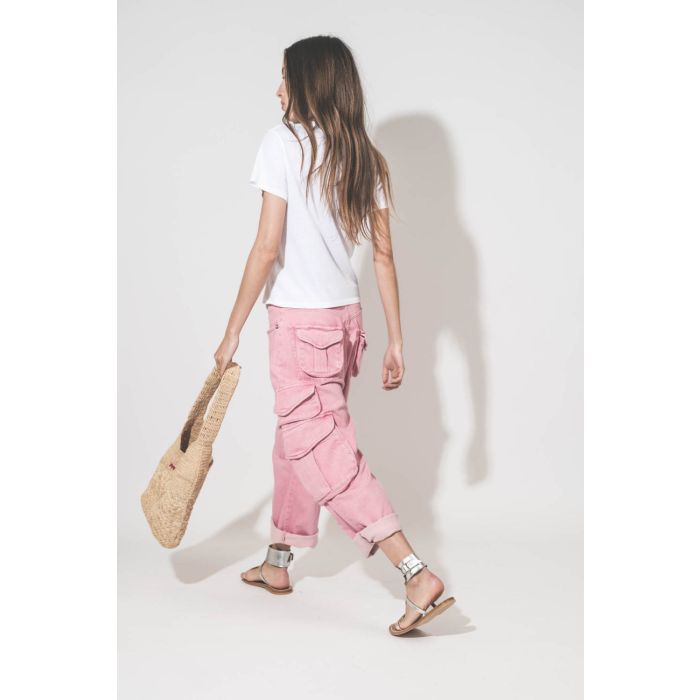 Jean taille basse oversized en toile rose multi-poches Cargo R13 denim. Porté de profil dos avec un tee-shirt blanc Little The Great, des sandales en cuir argent Caravelle K.Jacques St-Tropez et un sac en raphia naturel Praia Isabel Marant. 