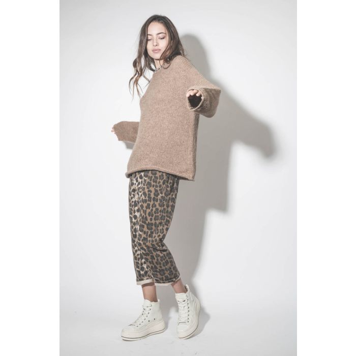 Jean baggy Tailored Drop en jean léopard R13. Porté avec un pull en alpaga beige.
