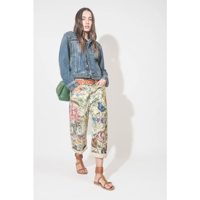 Jean en toile imprimé et brodé fleurs, papillons et tête de mort écru Floral X-Boyfriend R13. Porté avec un blouson en denim bleu.