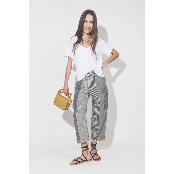 Pantalon oversize à rayures bleues Cargo Railroad R13. Porté de face avec un tee-shirt blanc col V The Great, des sandales plates en cuir noir Zenobie K.Jacques Saint-Tropez et un sac Pepito S jaune Mimosa Jérôme Dreyfuss. Bijoux en argent Maria Black, Pa