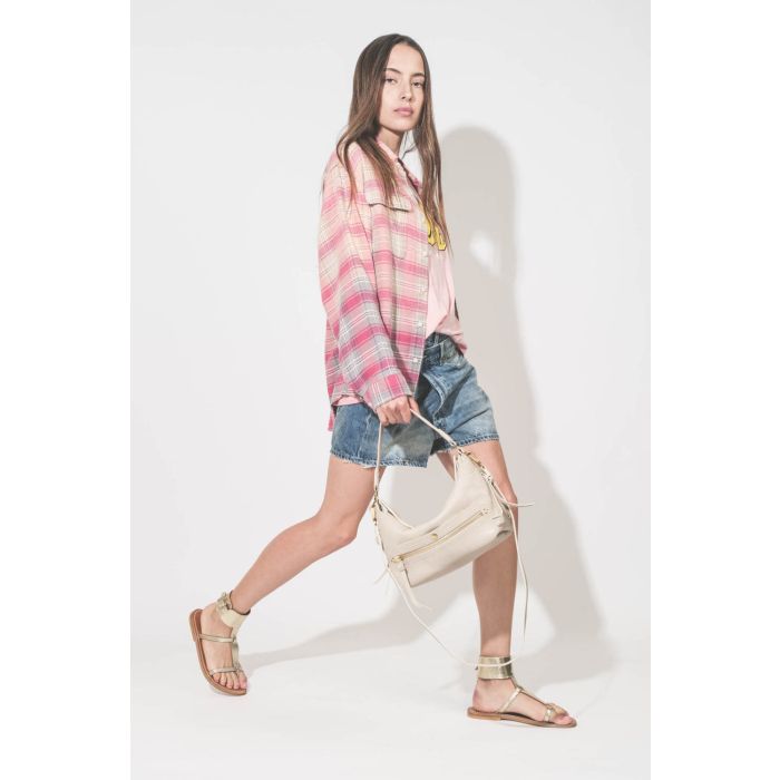 Short en jean Crossover délavage Bain Blue R13. Porté de profil avec une chemise rose à carreaux ouverte.