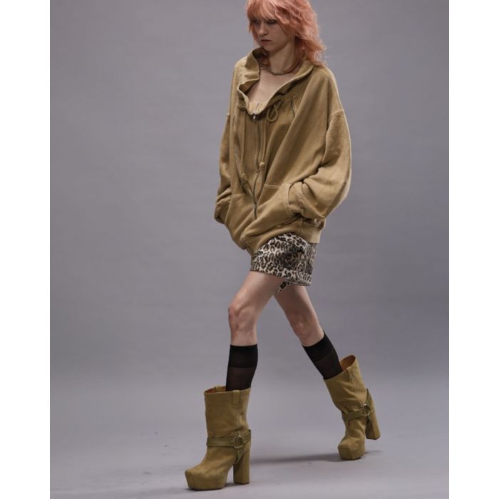 Short court en jean léopard R13. porté avec un sweat-shirt oversize beige. 