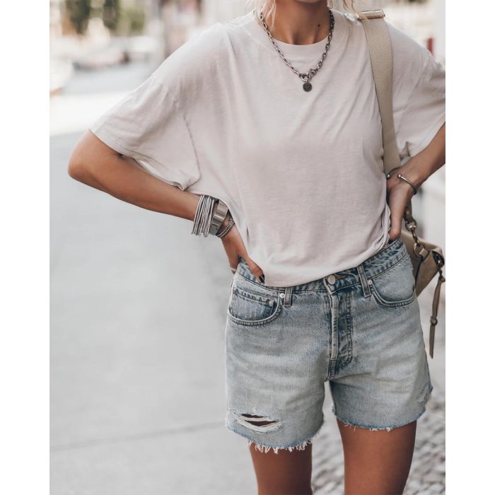 Short en jean bleu ciel usé Mikuta. Porté avec un tee-shirt écru Mikuta et des bijoux en argent Mikuta. 