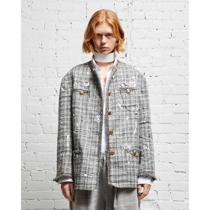 Veste oversized en tweed gris et taches de peinture avec des chaines, épingles à nourrice et badges R13. Porté de face. 