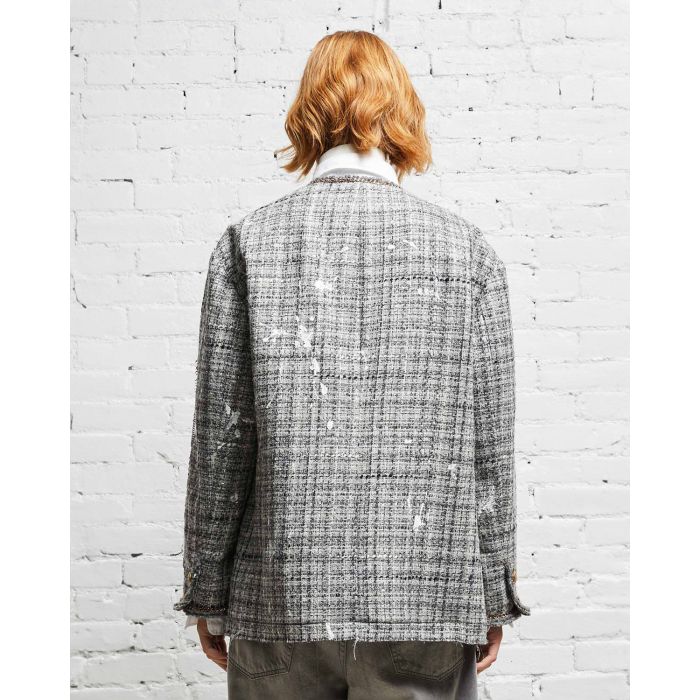 Veste oversized en tweed gris et taches de peinture avec des chaines, épingles à nourrice et badges R13. Porté de dos. 