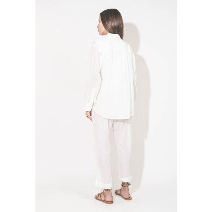 Chemise manches longues en voile de coton blanc Cove The Great. Portée ouverte de dos sur un tee-shirt sans manches Peak Shoulder blanc The Great et un pantalon sarouel assorti à la chemise en voile de coton blanc et des sandales en cuir Pony léopard Zeno