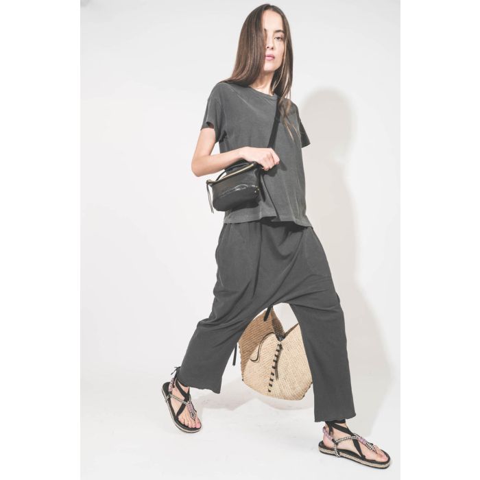 Pantalon sarouel court en jersey noir délavé The Great. Porté de profil avec un tee-shirt manches courtes noir délavé Boxy Crew The Great et des sandales en cordes tressées avec ruban Gypsa noir Isabel Marant. Pochette Lucky en cuir noir avec une bandouli