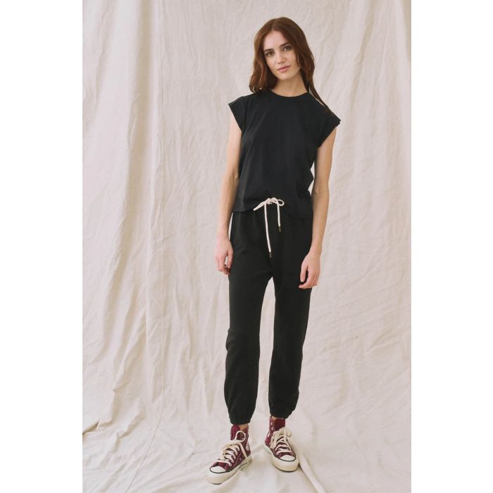 Tee-Shirt Peak Shoulder The Great en coton noir. Porté avec un jogging noir vu de face. 