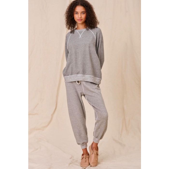 Sweatshirt encolure ronde en coton mélangé gris chiné surpiqures blanches The Slouch Sweatshirt The Great. Porté de face avec un bas de jogging assorti The Great. 