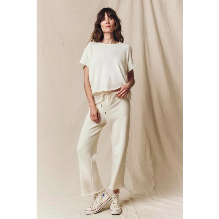 Tee-shirt court manches courtes en jersey écru True White The Great. Porté avec un bas de jogging assorti The Great. 