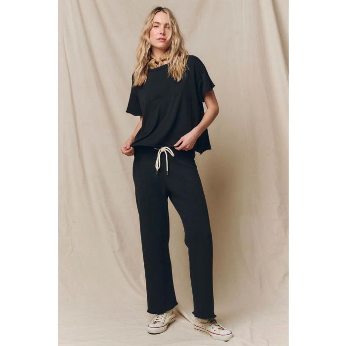 T-Shirt court manches courtes encolure ronde en jersey noir Almost Black The Crop Tee The Great. Porté de face avec un bas de jogging assorti The Great.
