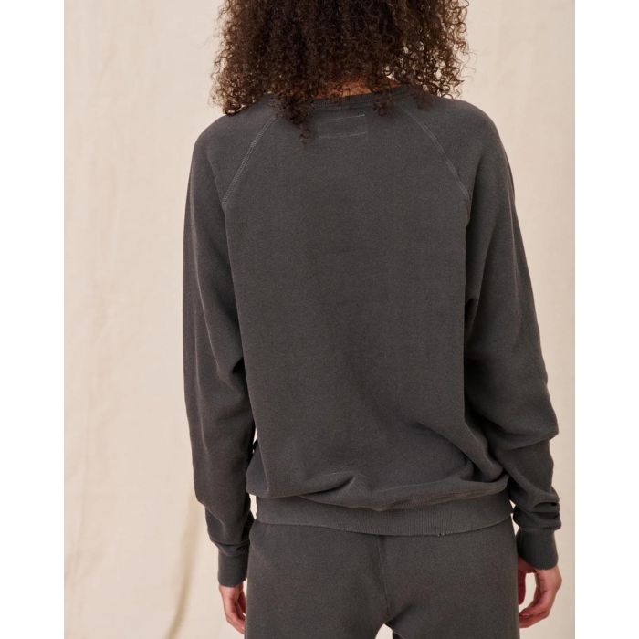 Sweatshirt College en coton noir délavé The Great, porté de dos avec un bas de jogging Crop de la même couleur et de la même marque. Surpiques ton sur ton.
