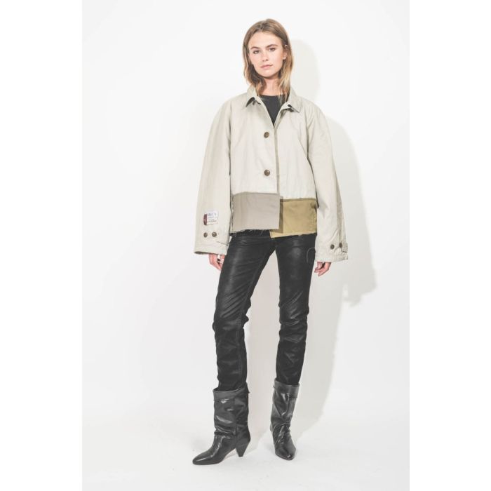 Trench court Oligos en tissus recyclés beige, création unique Yekaterina Ivankova porté de face avec un jean slim en faux cuir noir.