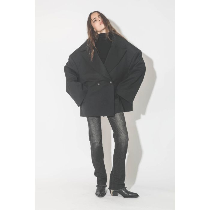 Veste oversize noire Kristeva Vautrait. Porté avec un jeans noir et des santiags.