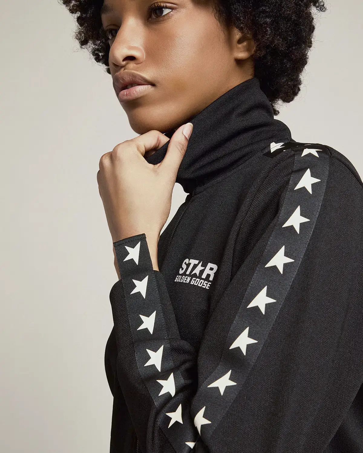 Veste de jogging noire avec étoiles blanches le long des manches Golden Goose. Porté de profil.
