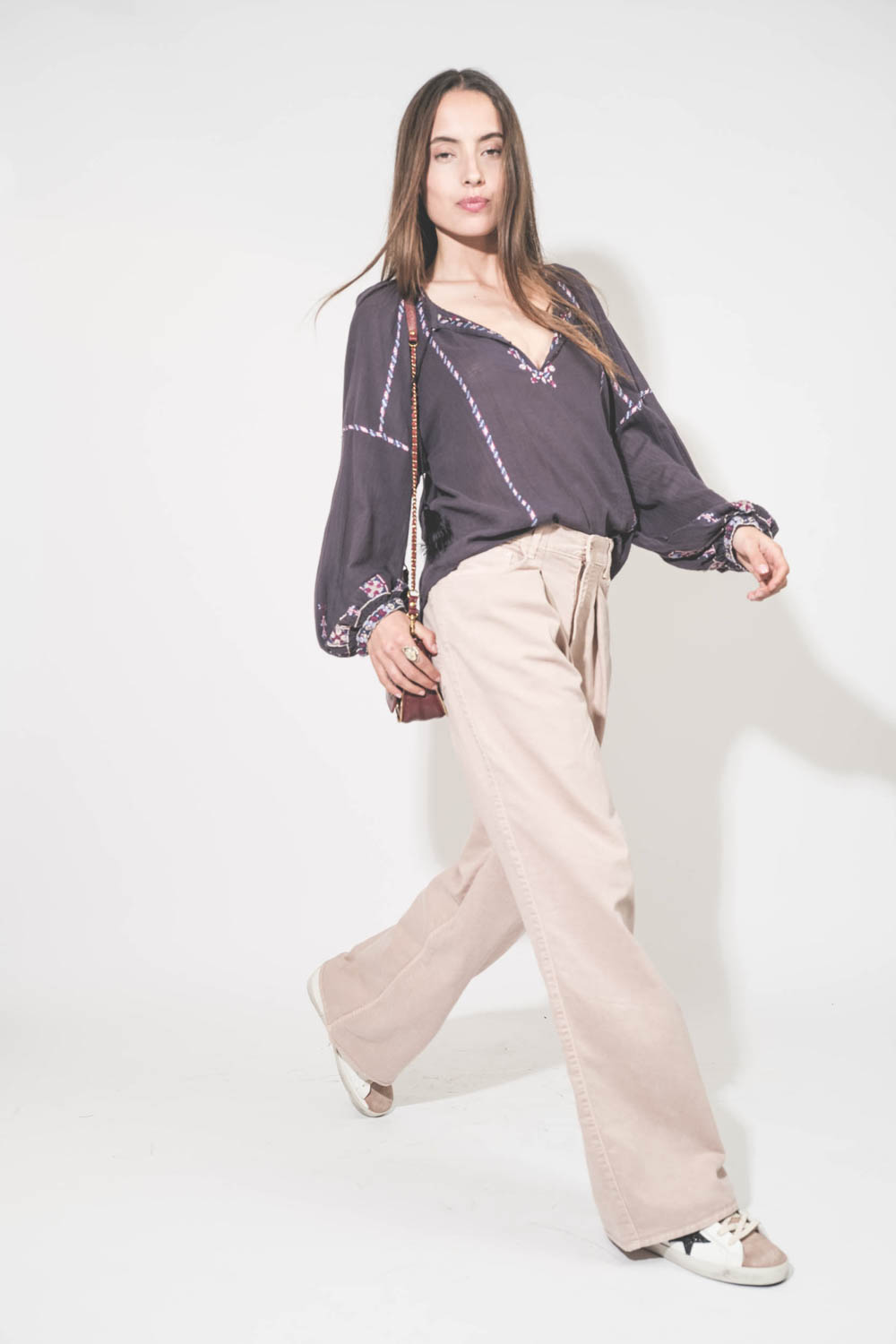 Jean large à pinces Twill 45 rose poudré Skin Candy Haikure. Porté de profil avec un top manches longues en voile de coton brodé bleu nuit lilas Fernanda Isabel Marant Etoile et des sneakers Super Star en cuir blanc languette rose Golden Goose. Sac Bobi S