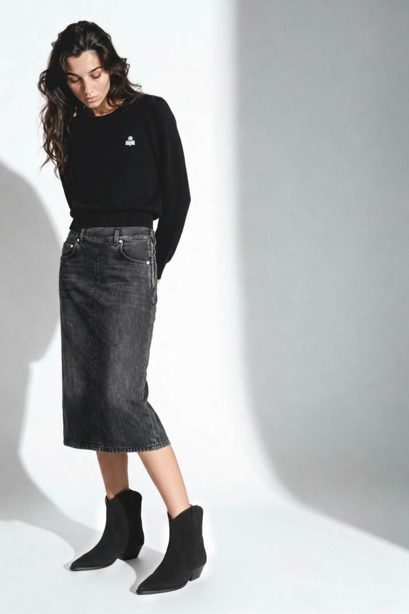 Jupe Kim Haikure en denim gris foncé. Portée avec des boots noires. 