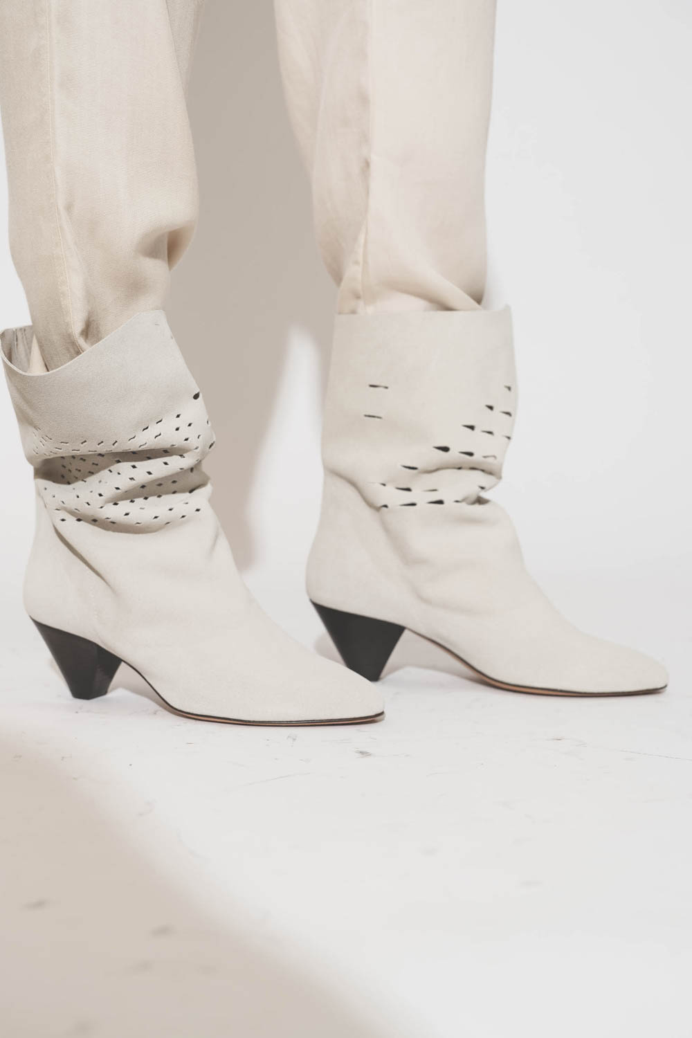 Boots à petits talons en cuir suédé souple et perforé craie Reachi Isabel Marant Etoile. Porté avec un pantalon écru.