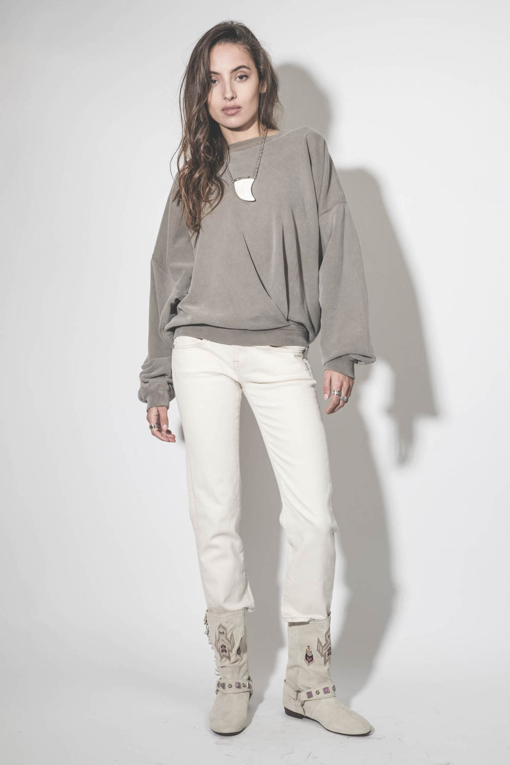 Bottes en cuir suédé écru brodées harnais et mini franges sur les côtés Siani Isabel Marant. Porté avec un sweat kaki et un jean écru.