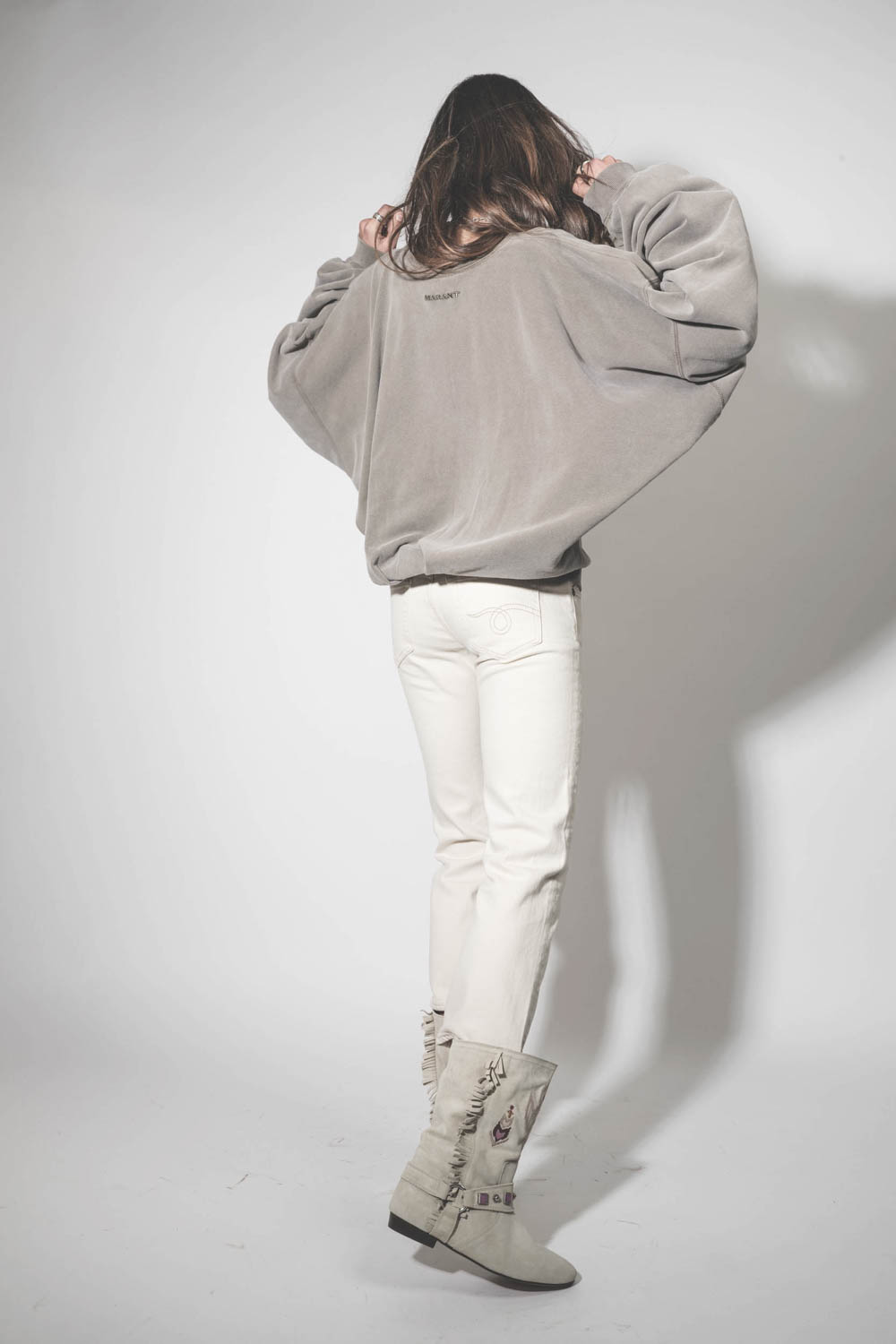Bottes en cuir suédé écru brodées harnais et mini franges sur les côtés Siani Isabel Marant. Porté de dos.