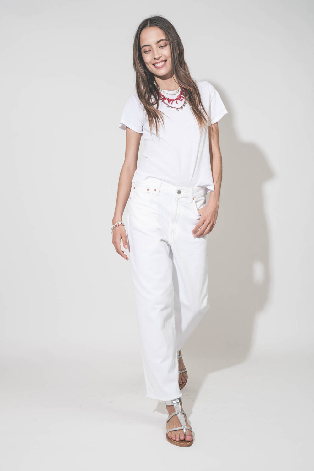 Collier de perles et os rouges Jolana Isabel Marant. Porté en accumulation avec un collier coquillage Noki et un collier Adriel en perles rouges et pampilles en métal argenté Isabel Marant. Tee-shirt blanc Little The Great, jean blanc Georgia Denimist et 