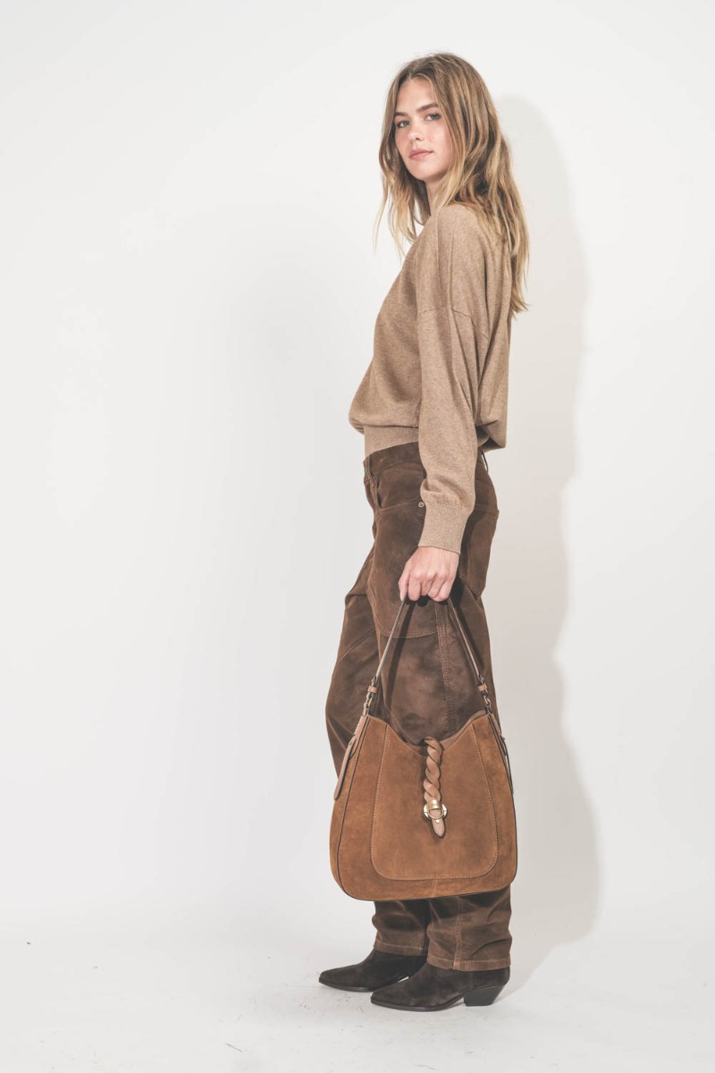 Pantalon Kelvina Isabel Marant Etoile en faux cuir effet vintage Tabacco. Porté de profil avec une paire de santiag.
