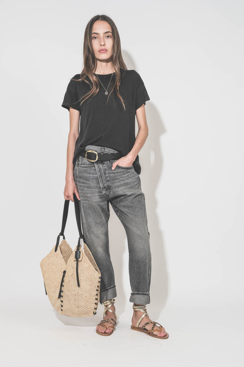 Panier en osier naturel finition cuir noir porté main ou épaule grand modèle Tampa Isabel Marant. Porté main de profil avec un tee-shirt noir Boxy Crew The Great et un jean Crossover Leyton Black R13 Denim. Ceinture Dara Isabel Marant.