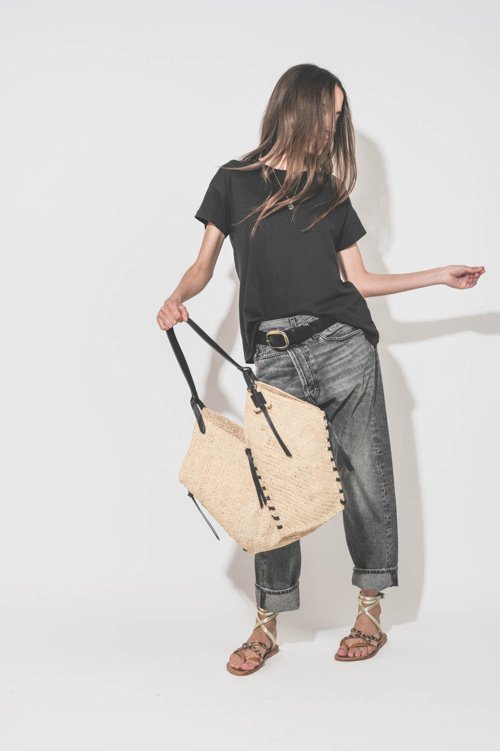 Panier en osier naturel finition cuir noir porté main ou épaule grand modèle Tampa Isabel Marant. Porté main de face avec un tee-shirt noir Boxy Crew The Great et un jean Crossover Leyton Black R13 Denim. Ceinture Dara Isabel Marant.