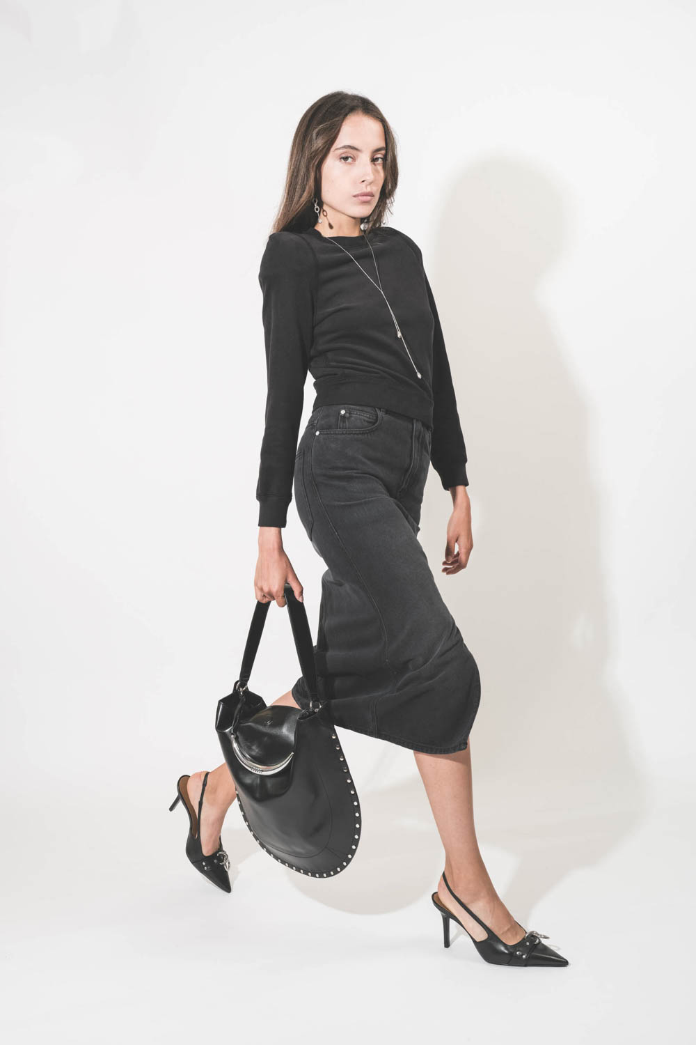 Sac bandoulière courte porté épaule ou porté main en cuir lisse noir poignée bijou en métal argenté Oskan Hobo Isabel Marant. Porté de profil.