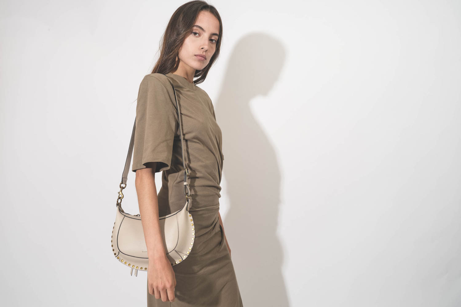 Mini sac en cuir grainé écru clouté finition métal doré Oskan Moon Isabel Marant. Porté de face. 