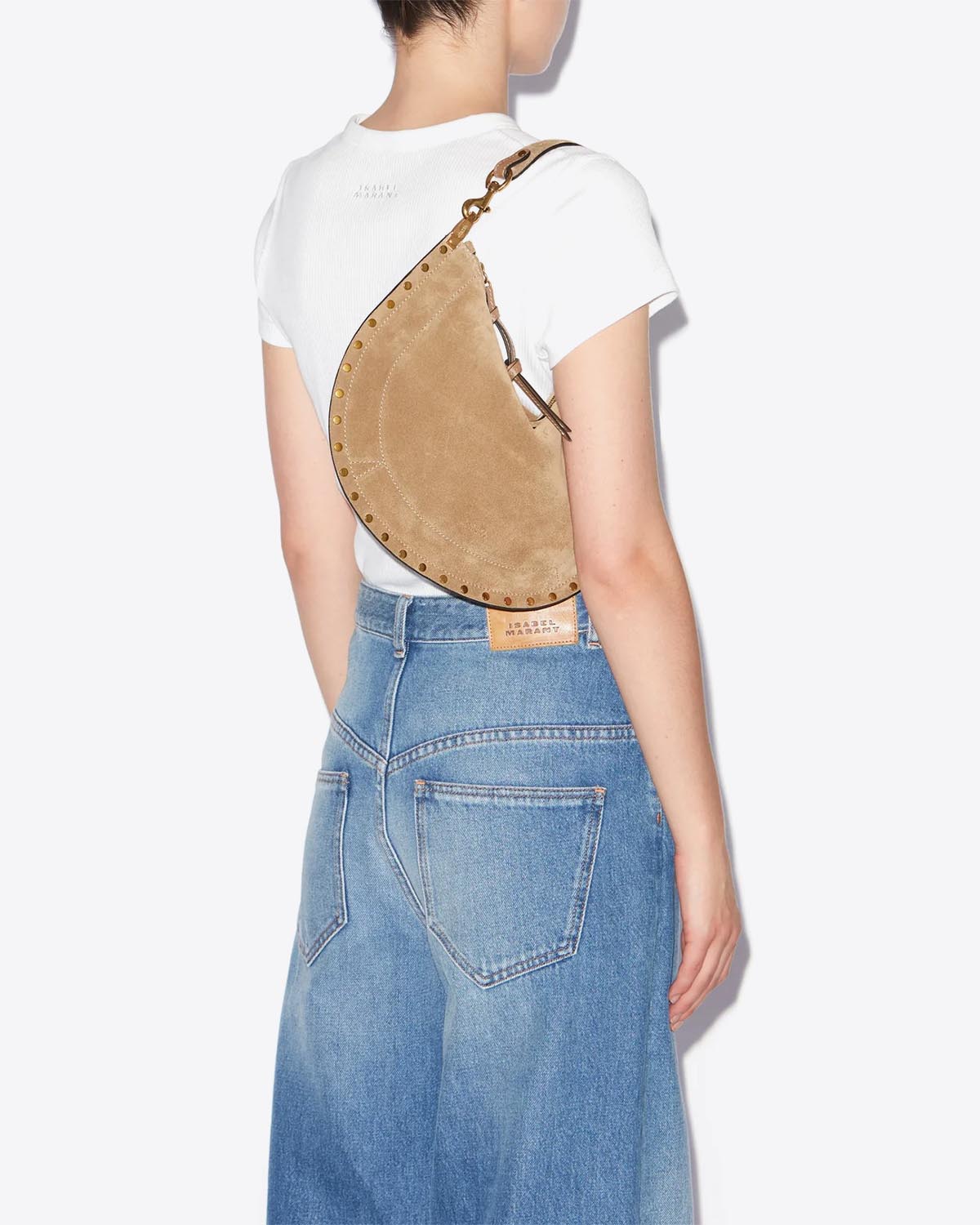 Sac Oskan Soft Zip Isabel Marant en cuir suédé taupe et clouté. Bandoulière courte pour un porté main ou épaule et une bandoulière longue pour un porté épaule ou croisé. Porté épaule avec la anse courte.